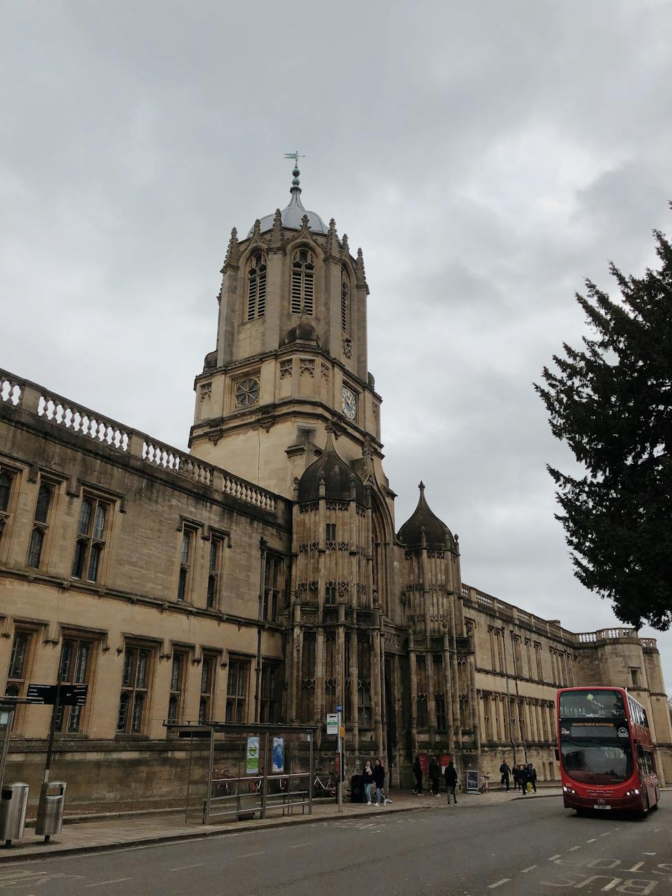 a low angle shot of tom tower under the white clouds