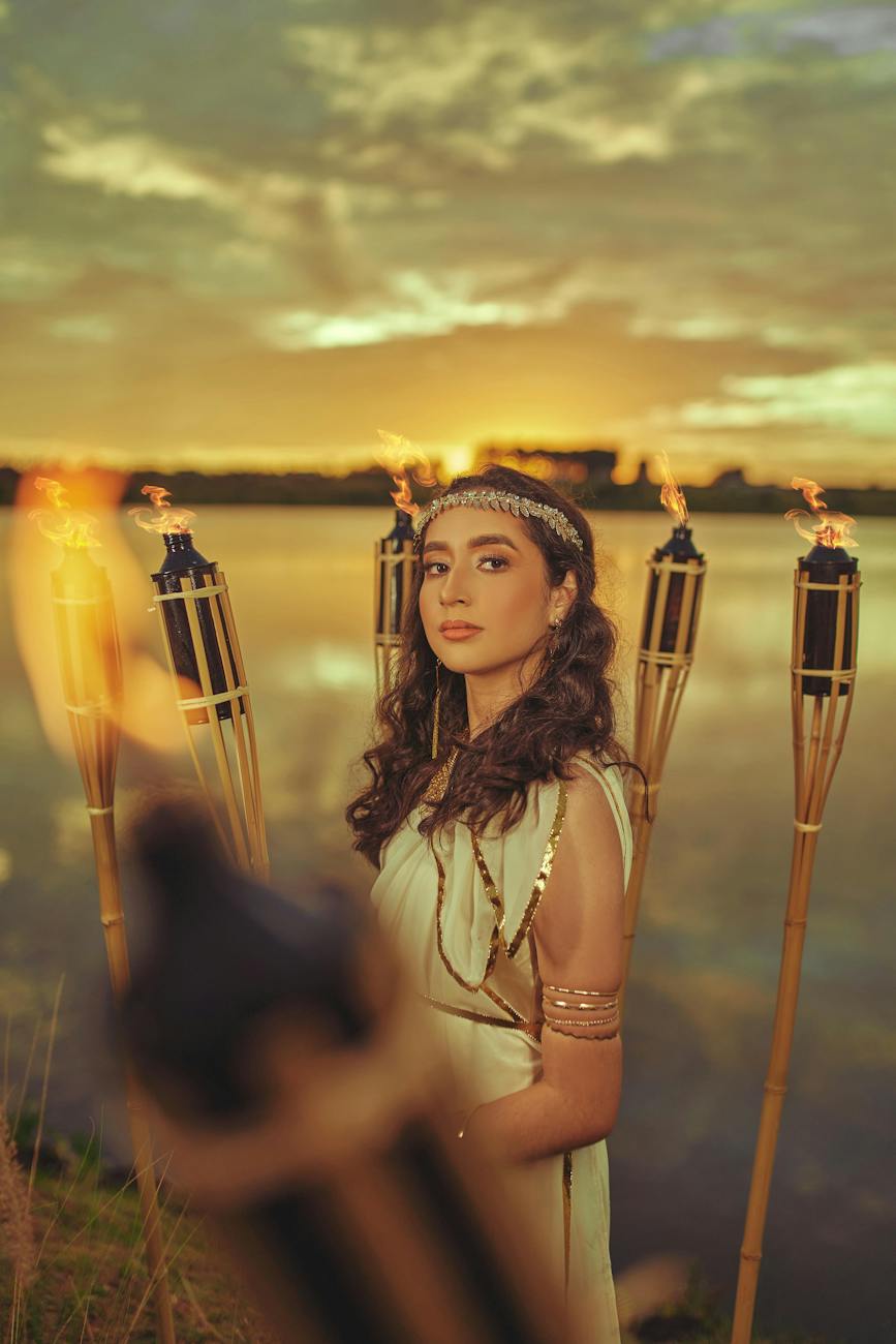 woman in white dress standing beside lighted torch