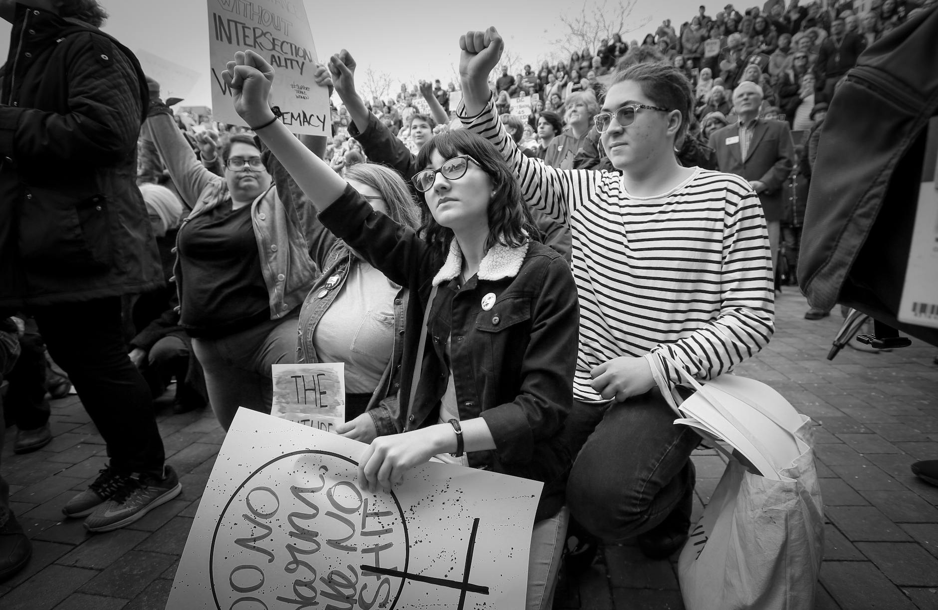 grayscale photo of people holding banner