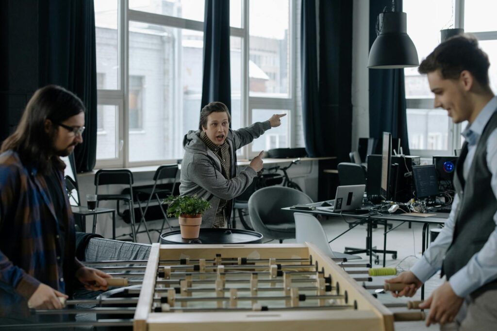 employee shouting at colleagues playing foosball in the office