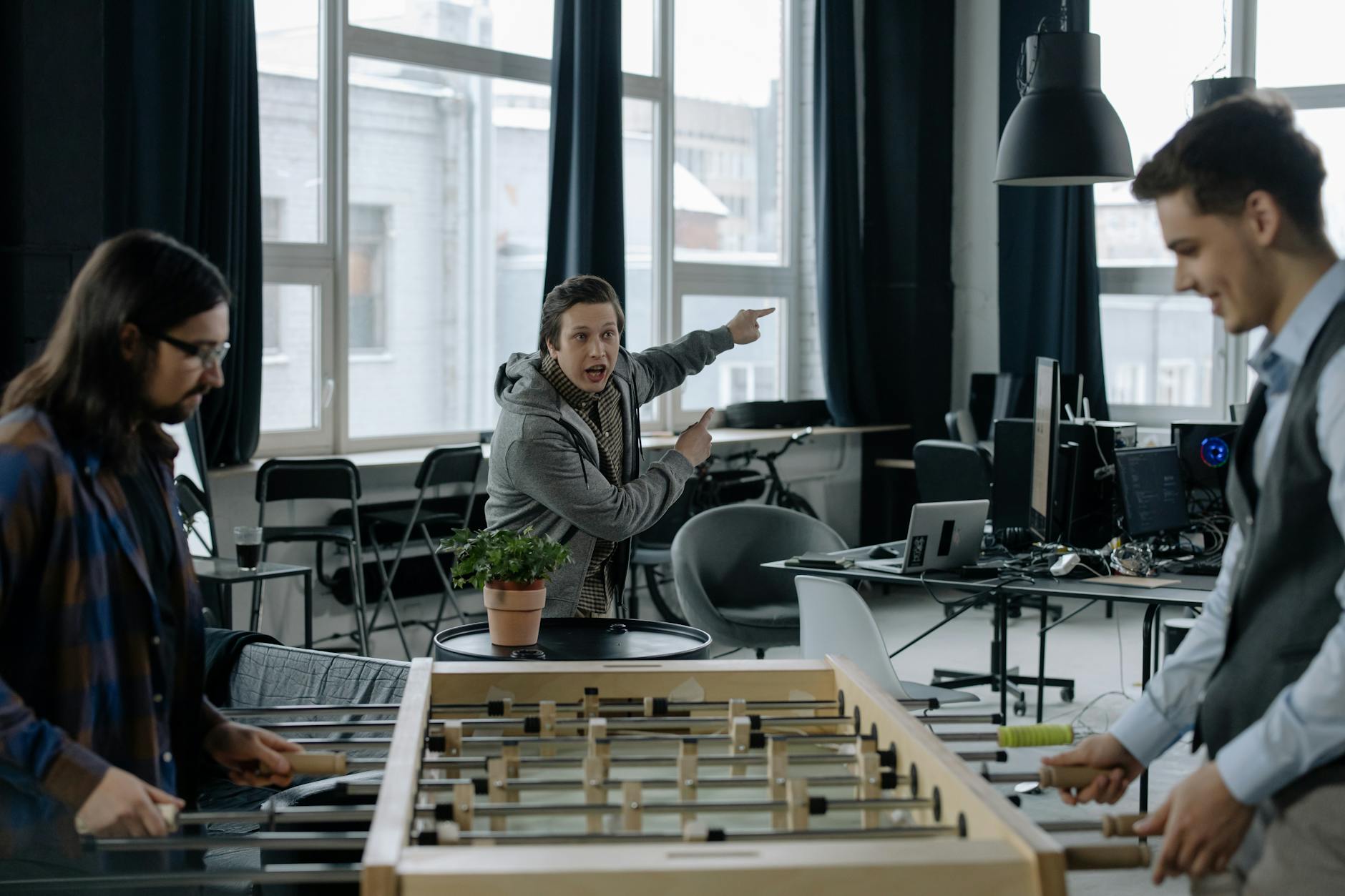 employee shouting at colleagues playing foosball in the office
