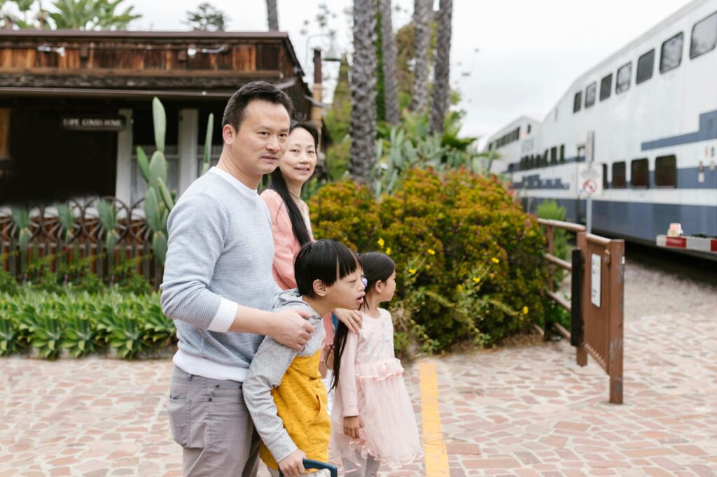 parents with a down syndrome son and cute daughter standing on train station platform